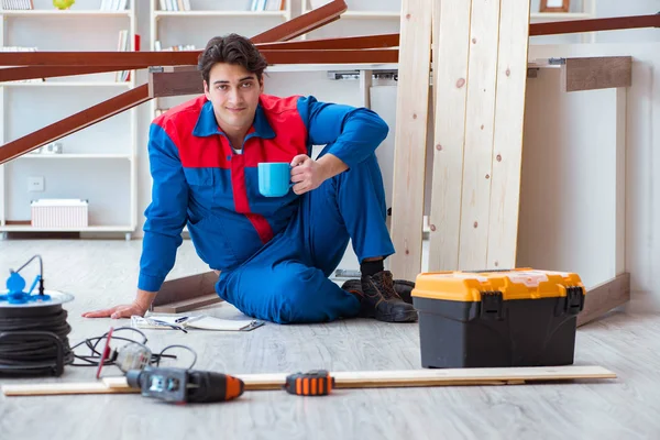 İnşaatta defter planlama yapan genç bir marangoz.