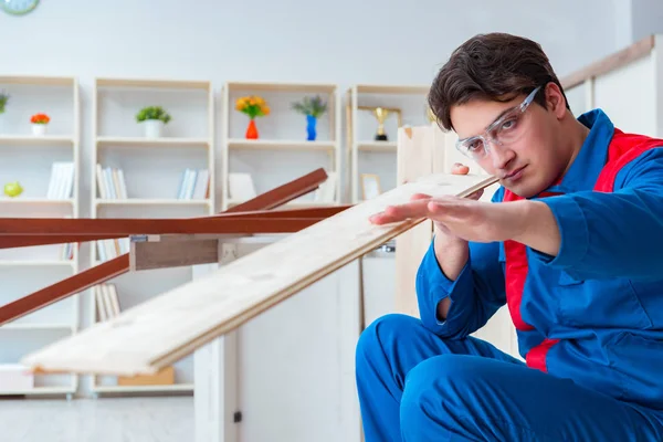 Genç marangoz ahşap kalaslarla çalışıyor.