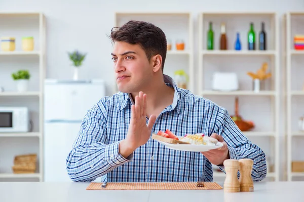 Jonge man eet smakeloos eten thuis voor de lunch — Stockfoto