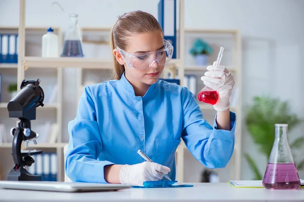 Kvinnlig forskare som utför ett experiment i ett laboratorium — Stockfoto