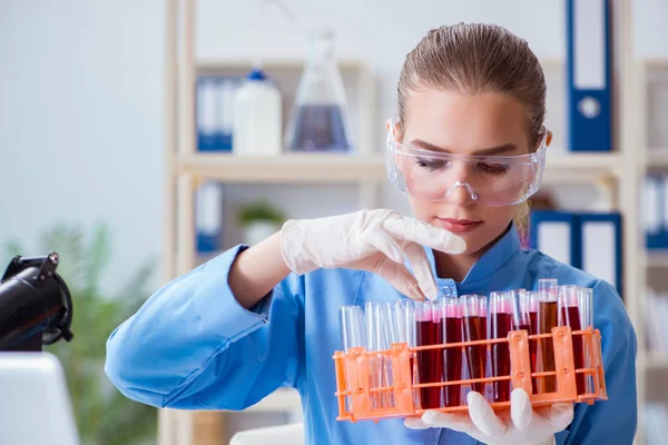 Bir laboratuarda deney yapan kadın bir bilim adamı.