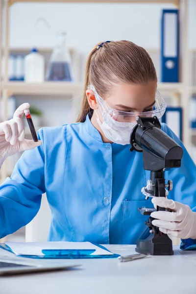 Bir laboratuarda deney yapan kadın bir bilim adamı.