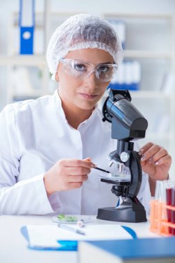 Bir laboratuarda deney yapan kadın bir bilim adamı.