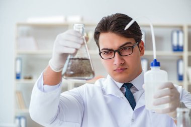 Genç araştırmacı bilim adamı bir su testi kirliliği araştırması yapıyor.