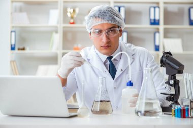 Genç araştırmacı bilim adamı bir su testi kirliliği araştırması yapıyor.