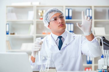 Genç araştırmacı bilim adamı bir su testi kirliliği araştırması yapıyor.