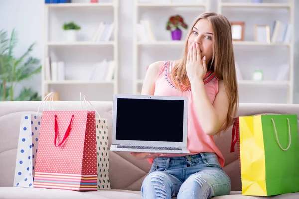 Mujer joven con bolsas de compras en el interior de casa en el sofá —  Fotos de Stock