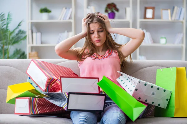 Jonge vrouw met boodschappentassen binnen op de bank — Stockfoto