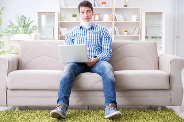 Man freelancer in a cervical collar neck brace working from home — Stock Photo, Image