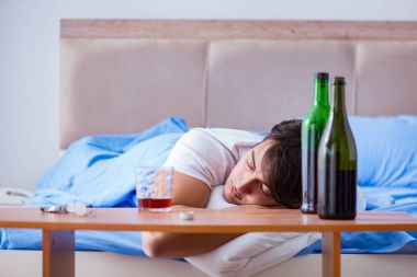 Yatakta içen alkolik adam depresyona giriyor.