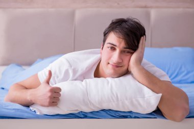 Uykusuzluk çeken bir adam yatakta yatıyor.