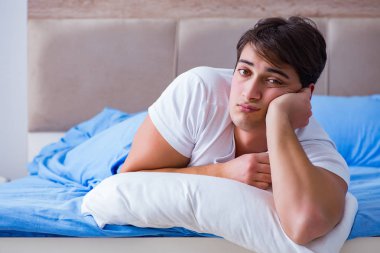 Uykusuzluk çeken bir adam yatakta yatıyor.