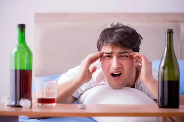 Man alkoholhaltiga drycker i sängen går igenom bryta upp depression — Stockfoto