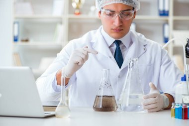 Genç araştırmacı bilim adamı bir su testi kirliliği araştırması yapıyor.