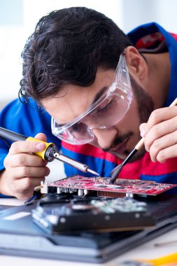 Bilgisayar dizüstü bilgisayarının tamirinde çalışan tamirci.