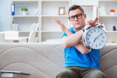 Sınavlara hazırlanan genç öğrenci kanepede ders çalışıyor.