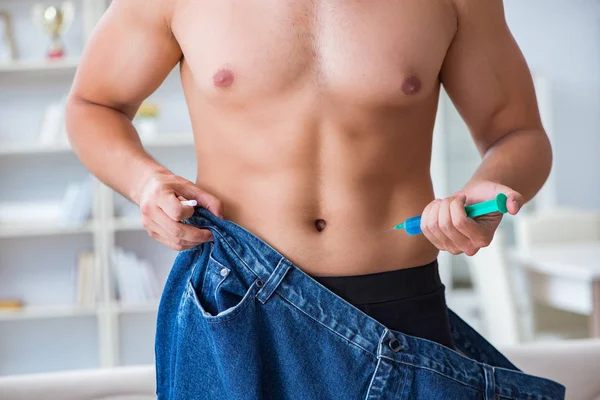 Kilo verme konseptinde büyük beden pantolon giyen bir adam.