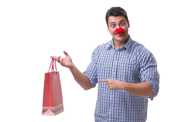 El hombre con una nariz roja divertida sosteniendo un regalo de bolsa de compras es —  Fotos de Stock