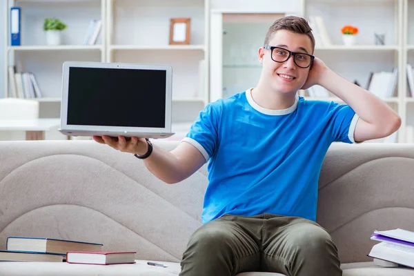 Sınavlara hazırlanan genç öğrenci kanepede ders çalışıyor.