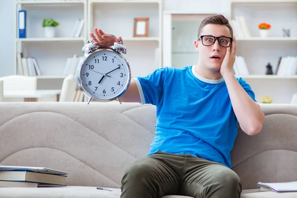 Sınavlara hazırlanan genç öğrenci kanepede ders çalışıyor.