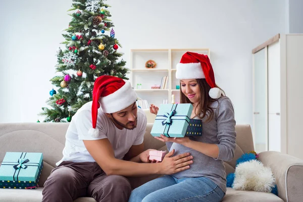 Genç aile Noel 'i kutlayan bir bebek bekliyor.