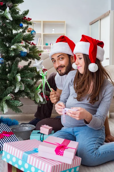 Genç aile Noel 'i kutlayan bir bebek bekliyor.