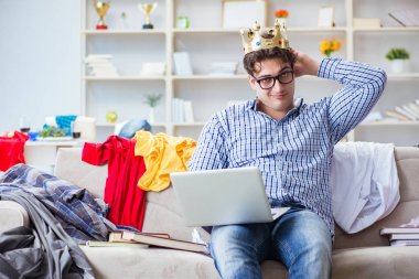 Genç adam dağınık bir odada çalışıyor.