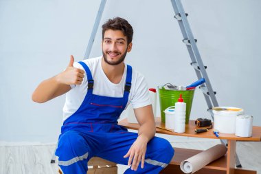 Repairman doing renovation repair in the house with paper wallpa clipart
