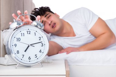 Yatakta uykusuzluk çeken bir adam.