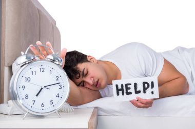 Yatakta uykusuzluk çeken bir adam.