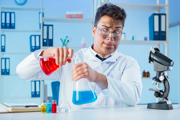 Zabawny szalony chemik pracujący w laboratorium. — Zdjęcie stockowe