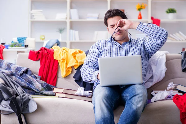 Jongeman aan het werk in rommelige kamer — Stockfoto