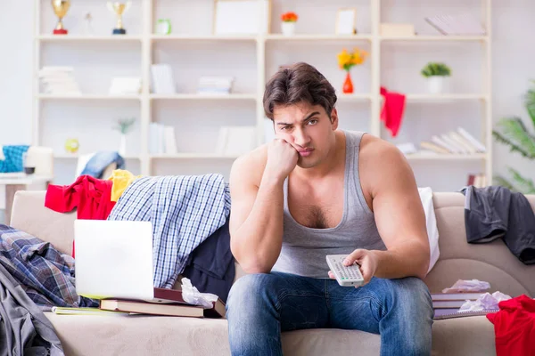 Jongeman aan het werk in rommelige kamer — Stockfoto