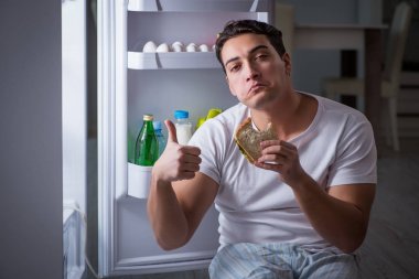 Buzdolabındaki adam gece yemek yiyor.