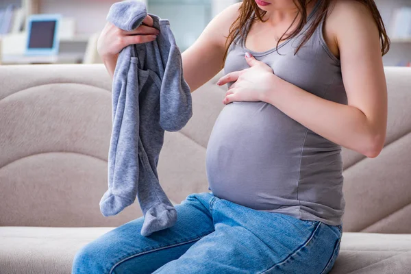 Mujer embarazada con barriga sentada en un sofá en casa — Foto de Stock