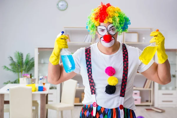 Funny clown doing cleaning at home