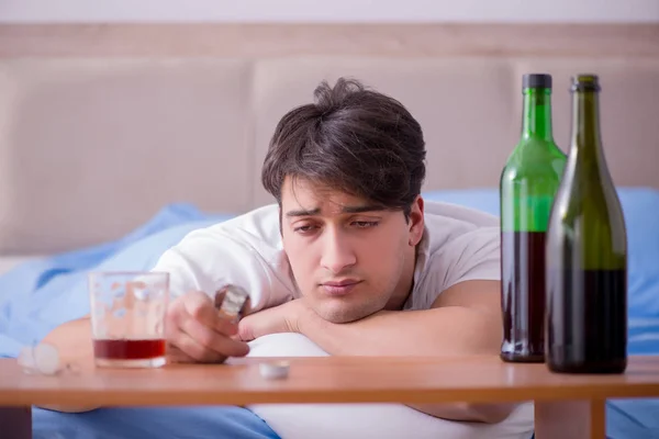 Férfi alkoholista iszik az ágyban megy keresztül szakítás depresszió — Stock Fotó