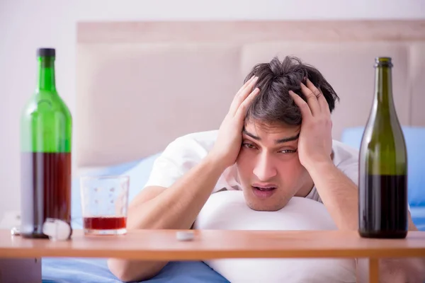 Man alkoholhaltiga drycker i sängen går igenom bryta upp depression — Stockfoto