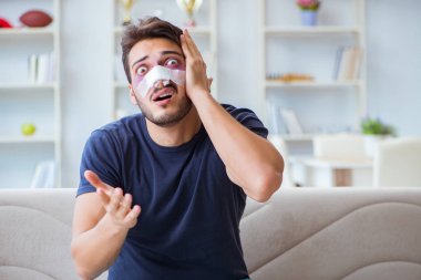 Genç adam estetik cerrahi burnundan sonra evde iyileşiyor.
