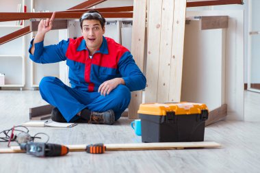 İnşaatta defter planlama yapan genç bir marangoz.