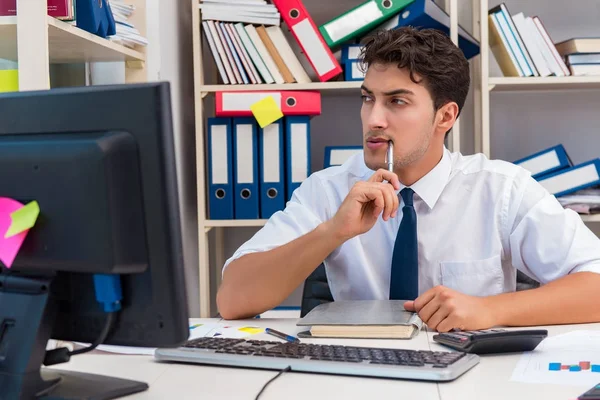 Homme d'affaires travaillant dans le bureau avec des piles de livres et de papiers — Photo