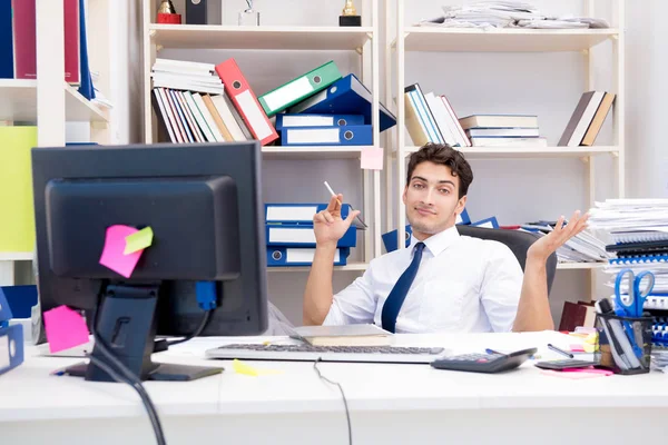 Empresario trabajando en la oficina con montones de libros y papeles — Foto de Stock