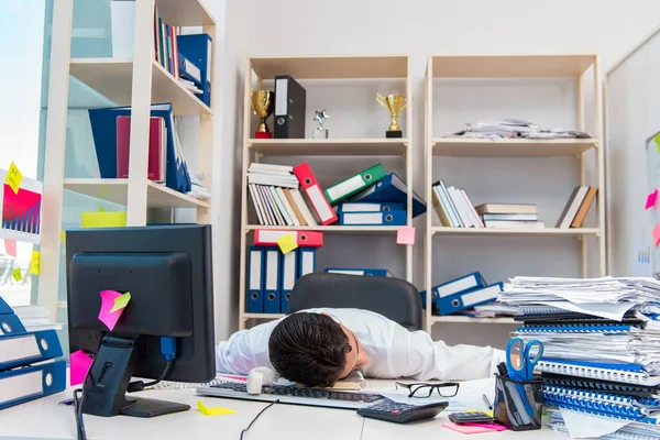 Empresario trabajando en la oficina con montones de libros y papeles — Foto de Stock