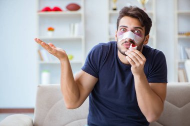 Genç adam estetik cerrahi burnundan sonra evde iyileşiyor.