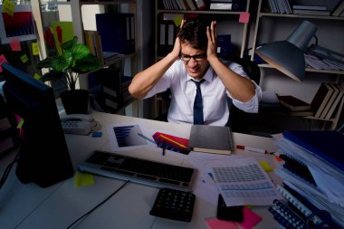 İş adamı ofiste geç saatlere kadar çalışıyor.