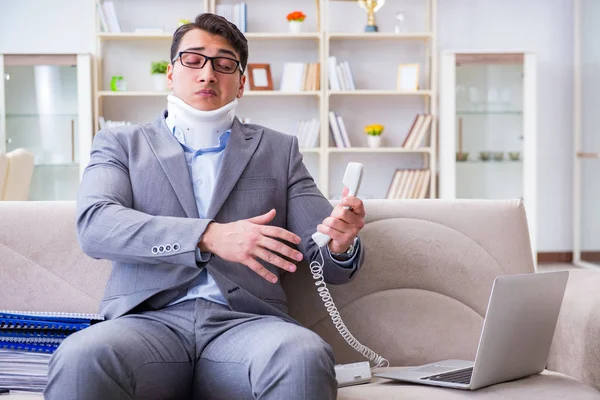 Man in neck brace cervical collar working from home teleworking