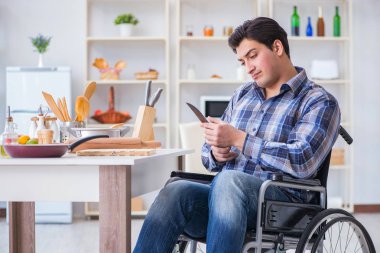 Engelli genç koca mutfakta çalışıyor.