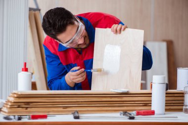 Yooung marangoz boyayla uğraşıyor.