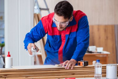 Yooung marangoz boyayla uğraşıyor.