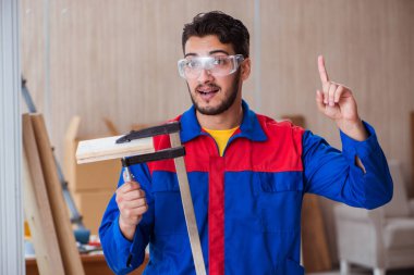 Klemplerle çalışan genç bir tamirci.